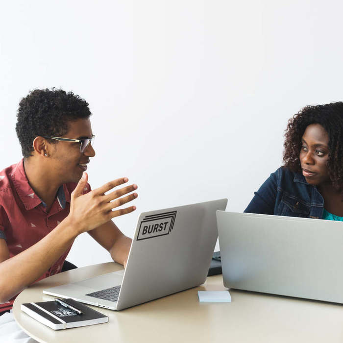 Large thumb man and woman brainstorming with laptops