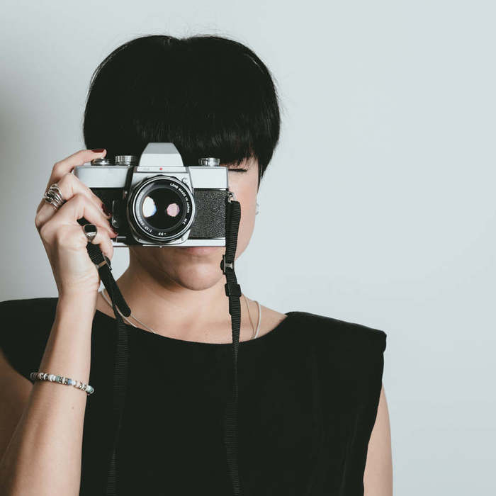 Large thumb woman with short dark hair takes a photo