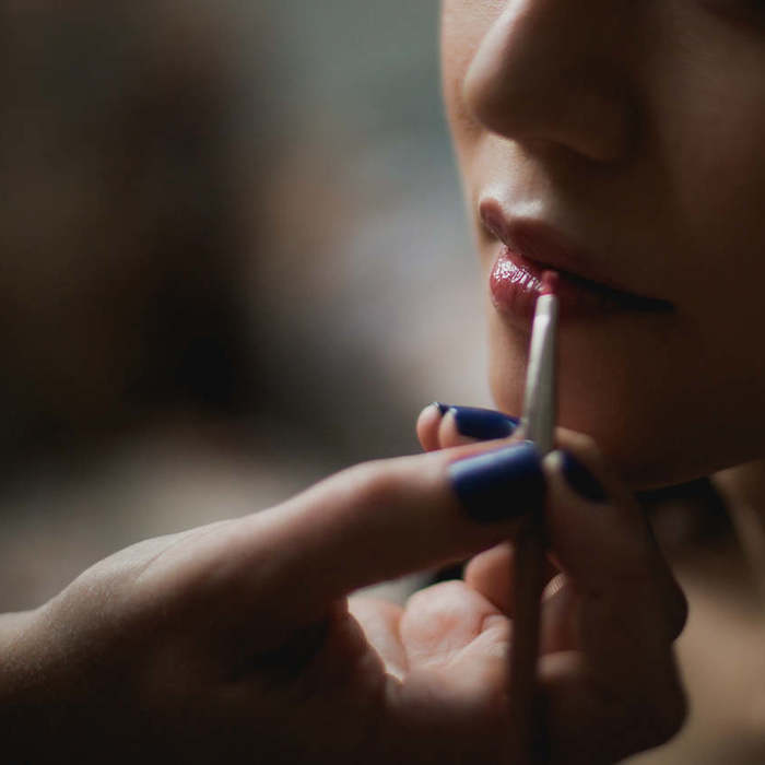 Large thumb natural lip gloss being applied