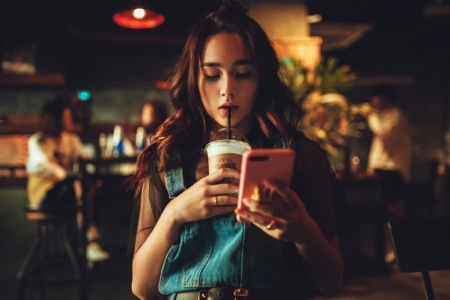 バーでスマホチェックする女性