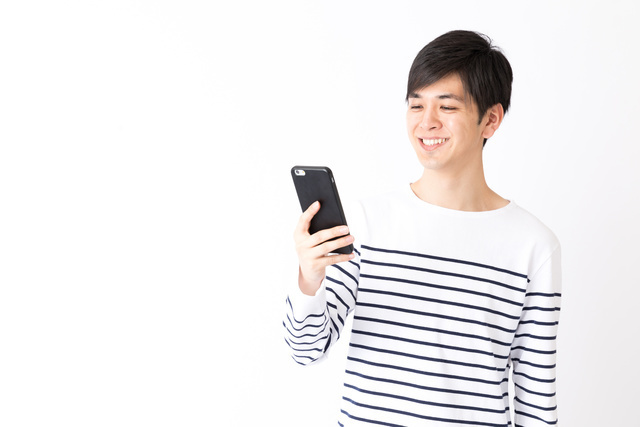 笑顔でスマホを見ている男性