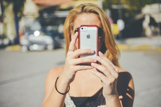 顔の前にスマホを出した女性