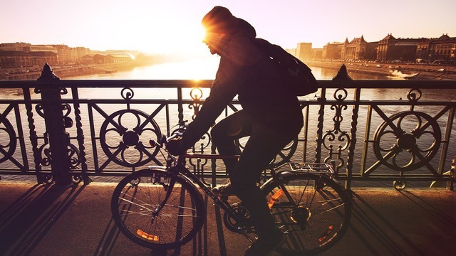 夕日と自転車に乗る男性