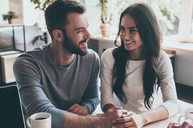 笑顔で見つめ合い手を握る男女