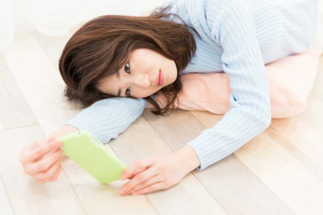 スマホを見て考える女性