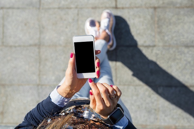 スマホを持って歩いている女性