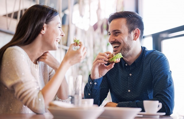 笑顔で食事をする男女